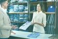 Woman seller assisting man in choosing shirt in menÃ¢â¬â¢s cloths s Royalty Free Stock Photo